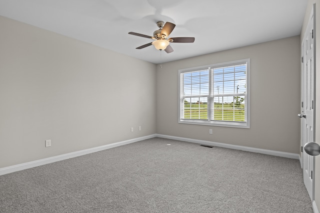 carpeted empty room featuring a ceiling fan and baseboards