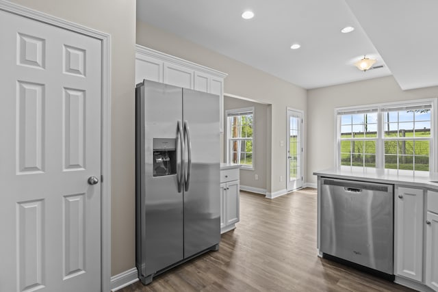 kitchen with appliances with stainless steel finishes, baseboards, white cabinets, dark wood-style floors, and recessed lighting