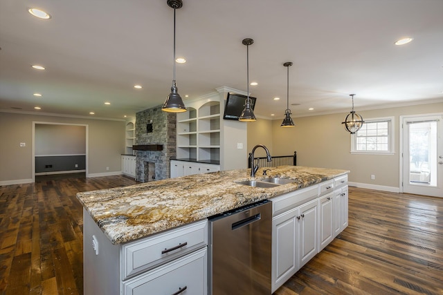 kitchen featuring dishwasher, a sink, baseboards, crown molding, and a kitchen island with sink