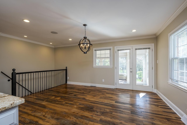 spare room with dark wood-type flooring, a chandelier, crown molding, recessed lighting, and baseboards