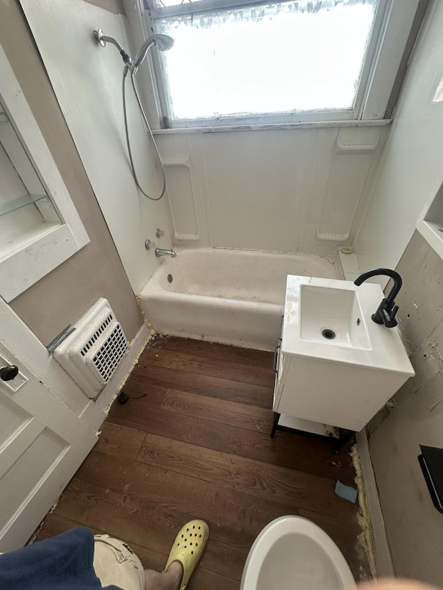 bathroom with hardwood / wood-style floors, bathtub / shower combination, and a sink