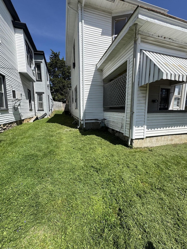 view of side of home with a yard