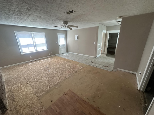 empty room featuring baseboards, a textured ceiling, a ceiling fan, and a smoke detector