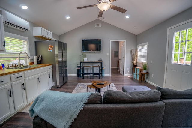 living area with visible vents, a ceiling fan, a healthy amount of sunlight, and an AC wall unit