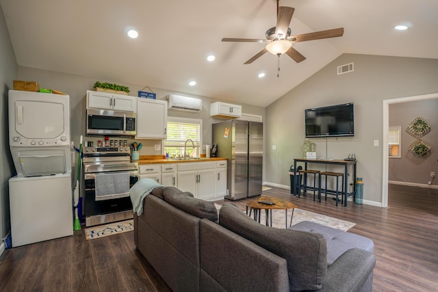 living room with a wall mounted air conditioner, stacked washer / dryer, dark wood-type flooring, visible vents, and ceiling fan