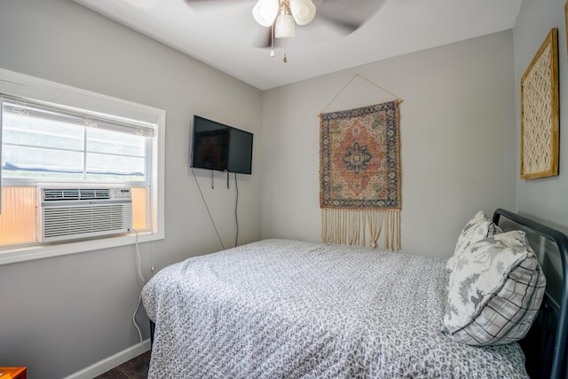 bedroom featuring cooling unit, wood finished floors, baseboards, and ceiling fan