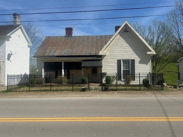 225 Mt Sterling Ave, Flemingsburg, KY 41041 - view of front of home with a fenced front yard, a chimney, metal roof, and a standing seam roof