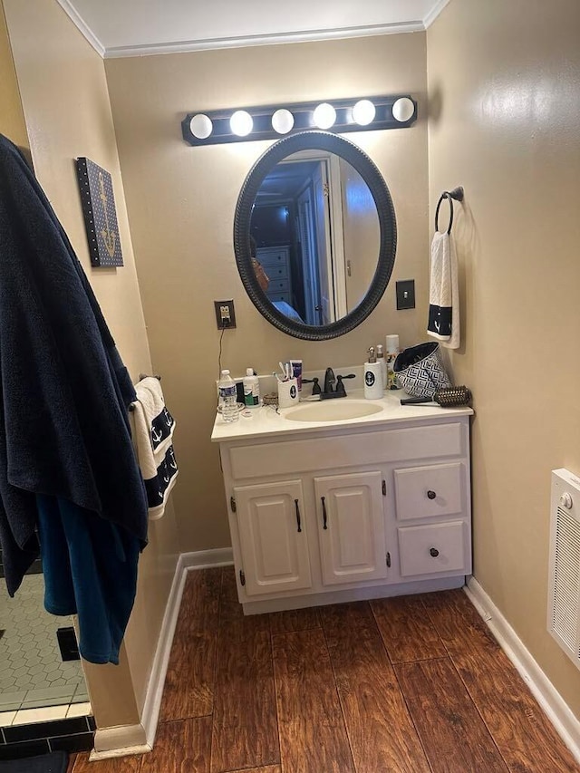 225 Mt Sterling Ave, Flemingsburg, KY 41041 - bathroom featuring wood finished floors, vanity, ornamental molding, visible vents, and baseboards