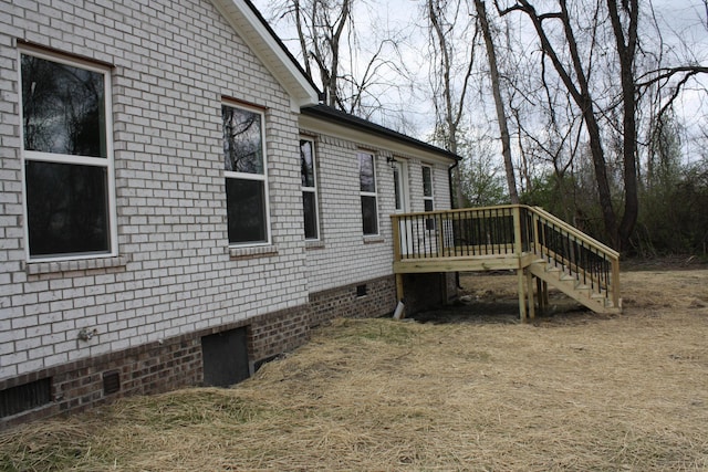 view of property exterior featuring crawl space, stairs, and a wooden deck