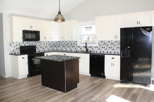 kitchen with black appliances, a sink, vaulted ceiling, decorative backsplash, and light wood-style flooring