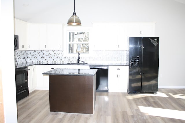 kitchen featuring black appliances, a sink, light wood-type flooring, and backsplash