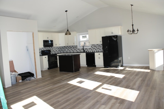 kitchen with black appliances, dark countertops, open floor plan, and high vaulted ceiling