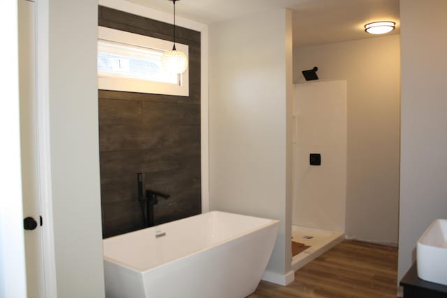 bathroom with walk in shower, wood finished floors, and a freestanding bath