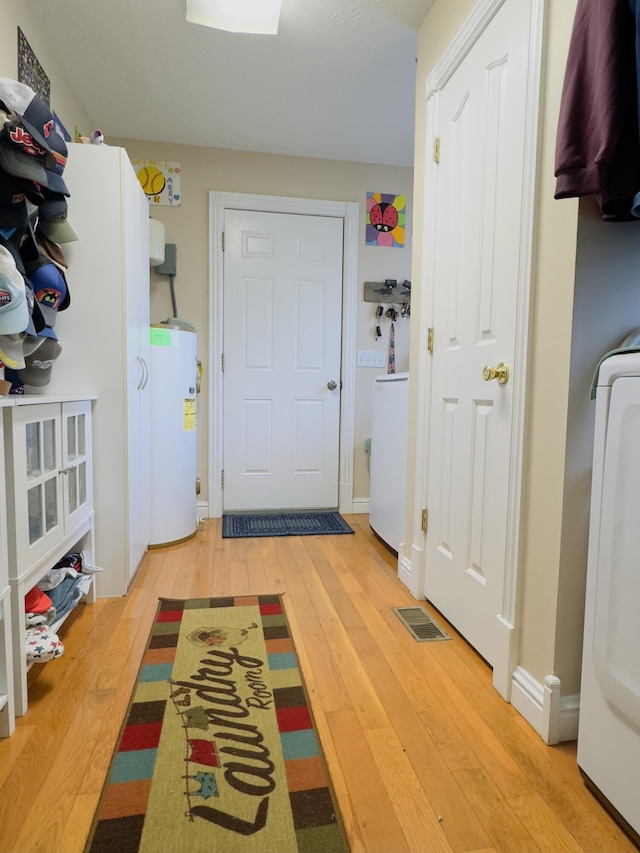 100 Dillon Ct, Berea, KY 40403 - interior space featuring electric water heater, light wood-type flooring, visible vents, and washer / clothes dryer