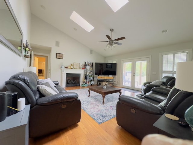 100 Dillon Ct, Berea, KY 40403 - living area featuring light wood finished floors, a skylight, high vaulted ceiling, and a fireplace with flush hearth