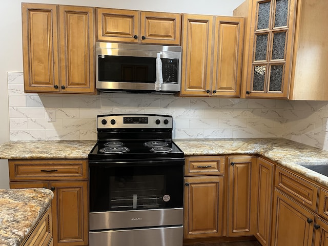 211 S Alta Ave, Danville, KY 40422 - kitchen featuring appliances with stainless steel finishes, brown cabinetry, and glass insert cabinets