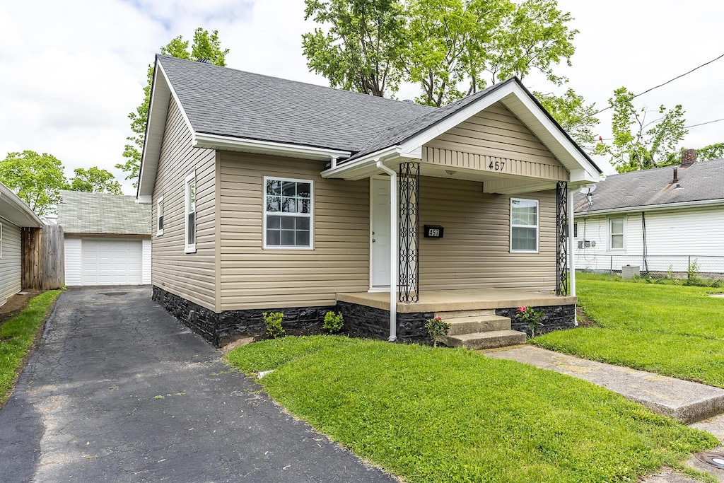 457 Lindberg Dr, Lexington, KY 40508 - bungalow-style house featuring a front lawn, an outdoor structure, roof with shingles, a porch, and driveway