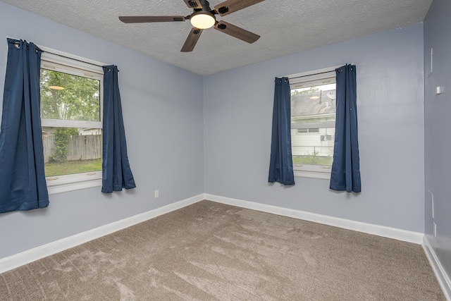 carpeted empty room featuring a ceiling fan, baseboards, and a textured ceiling