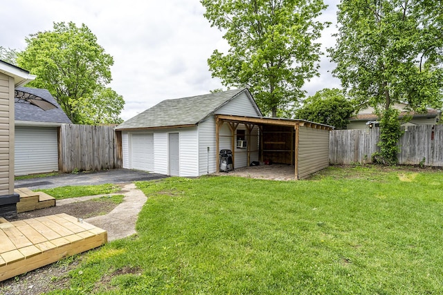 exterior space featuring fence, a garage, and an outbuilding