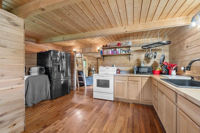kitchen with a sink, stainless steel appliances, wooden walls, beamed ceiling, and wood ceiling