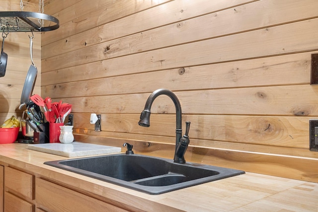 interior details featuring wooden walls, wooden counters, and a sink