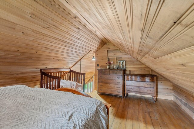 bedroom featuring vaulted ceiling, wood ceiling, wood walls, and hardwood / wood-style flooring