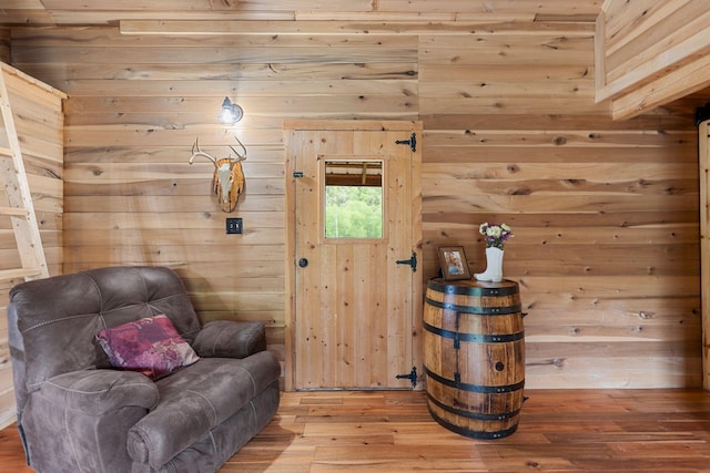 living area featuring wood walls and wood finished floors