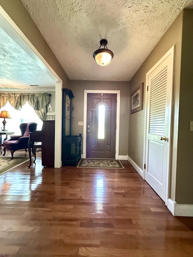 entrance foyer featuring baseboards, a healthy amount of sunlight, and wood finished floors