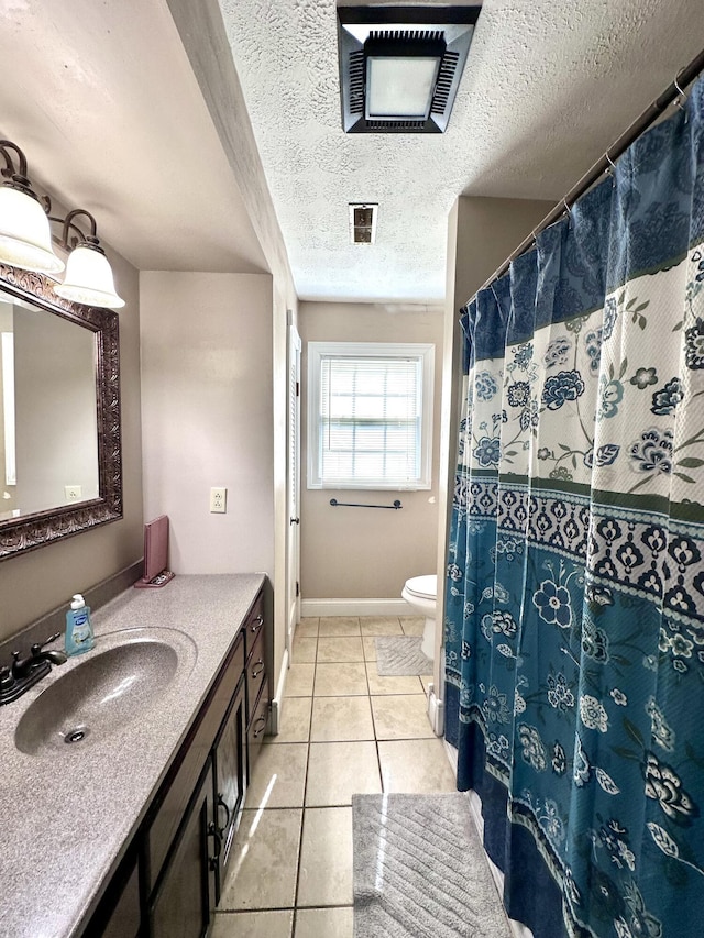 full bath featuring toilet, a textured ceiling, baseboards, tile patterned flooring, and vanity
