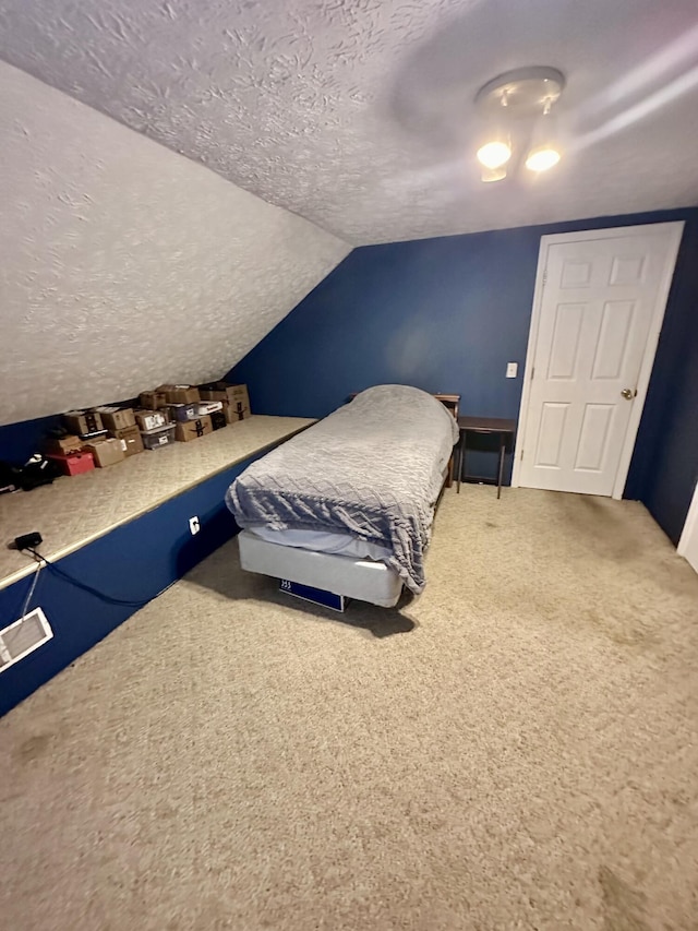 carpeted bedroom with a textured ceiling, vaulted ceiling, and baseboards