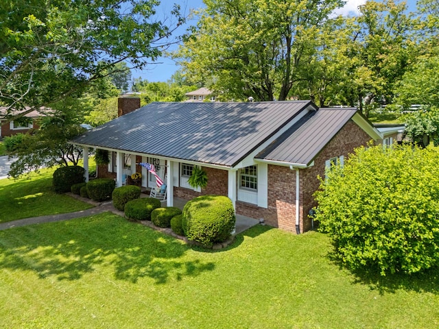 202 Leimaur Dr, Richmond, KY 40475 - view of front of home featuring brick siding, a chimney, a front yard, metal roof, and a porch