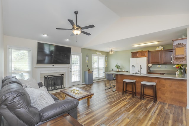 1208 Four Wynds Trl, Lexington, KY 40515 - living area featuring vaulted ceiling, a ceiling fan, light wood finished floors, and a fireplace with flush hearth