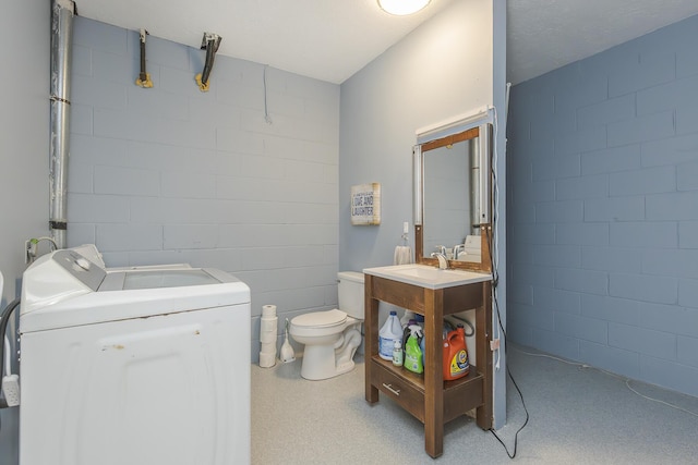 1208 Four Wynds Trl, Lexington, KY 40515 - bathroom with toilet, concrete block wall, vanity, and washing machine and clothes dryer