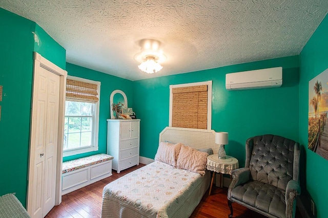 121 Meredith Ave, Frankfort, KY 40601 - bedroom featuring an AC wall unit, wood finished floors, a textured ceiling, and a closet