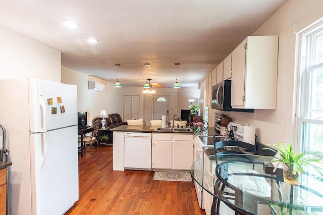 121 Meredith Ave, Frankfort, KY 40601 - kitchen featuring white appliances, a sink, dark countertops, a peninsula, and wood finished floors