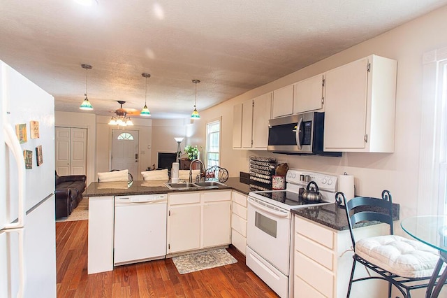 121 Meredith Ave, Frankfort, KY 40601 - kitchen with white appliances, a sink, dark countertops, a peninsula, and open floor plan