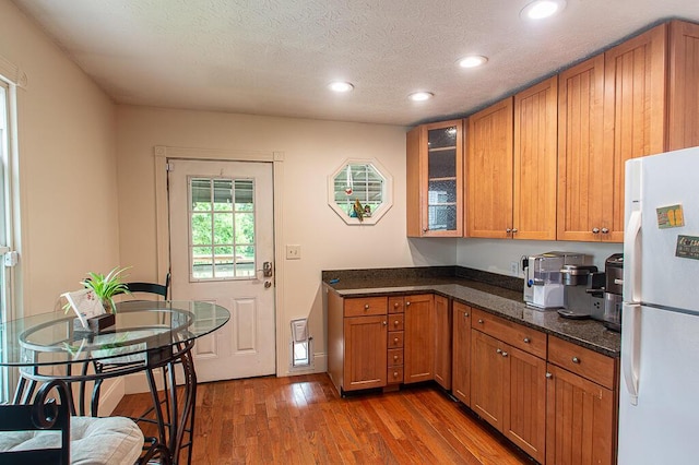121 Meredith Ave, Frankfort, KY 40601 - kitchen featuring freestanding refrigerator, recessed lighting, wood finished floors, brown cabinetry, and glass insert cabinets