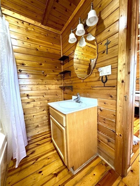 792 Tuggle Rd, Lancaster, KY 40444 - bathroom with wooden ceiling, vanity, wood walls, wood finished floors, and a tub