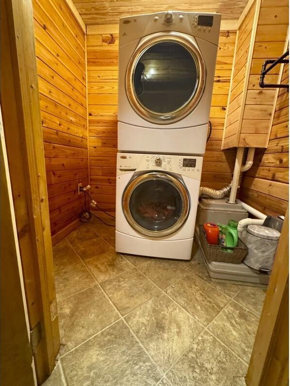 792 Tuggle Rd, Lancaster, KY 40444 - clothes washing area with stacked washer and clothes dryer and wood walls