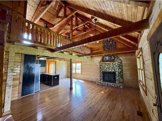 792 Tuggle Rd, Lancaster, KY 40444 - unfurnished living room with high vaulted ceiling, wood finished floors, a stone fireplace, and wooden walls