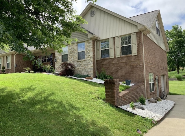 view of home's exterior featuring stone siding, brick siding, a yard, concrete driveway, and a garage