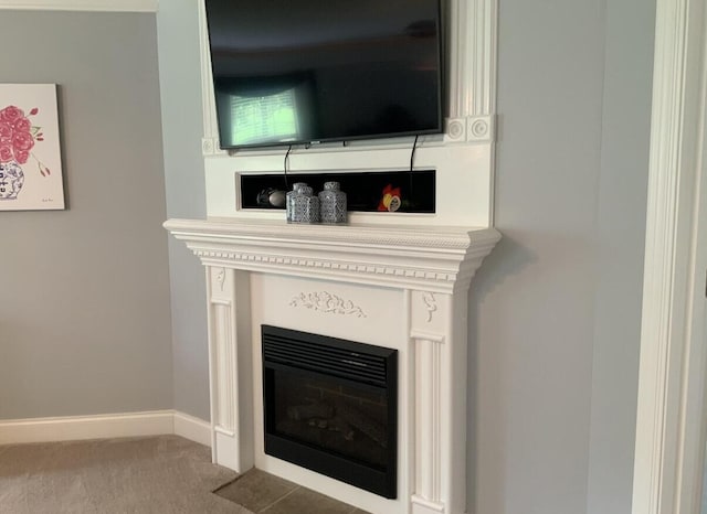 room details featuring carpet, baseboards, and a fireplace with flush hearth
