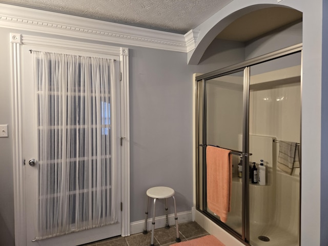 bathroom featuring baseboards, crown molding, and a textured ceiling