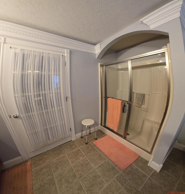 bathroom featuring tile patterned flooring, a textured ceiling, baseboards, and a shower stall