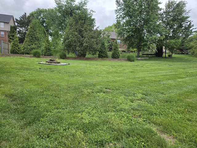 view of yard featuring fence and a fire pit