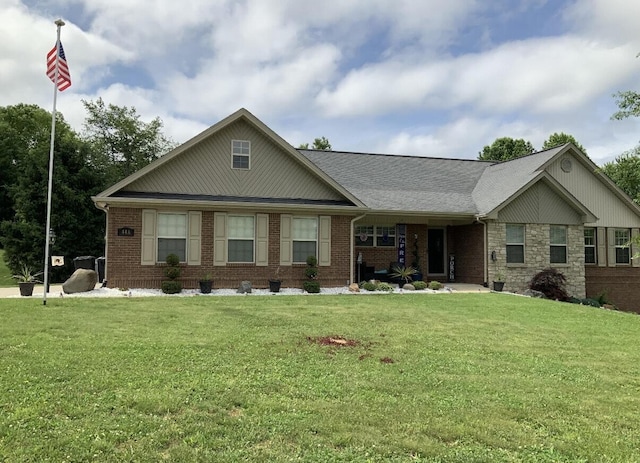 view of front of property featuring covered porch, brick siding, and a front yard