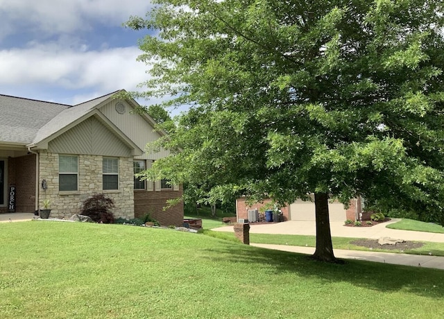 view of side of home featuring a yard, stone siding, and a shingled roof