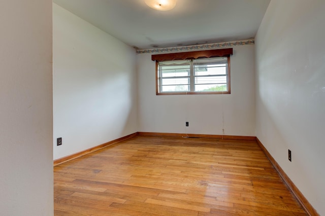 unfurnished room with light wood-type flooring and baseboards
