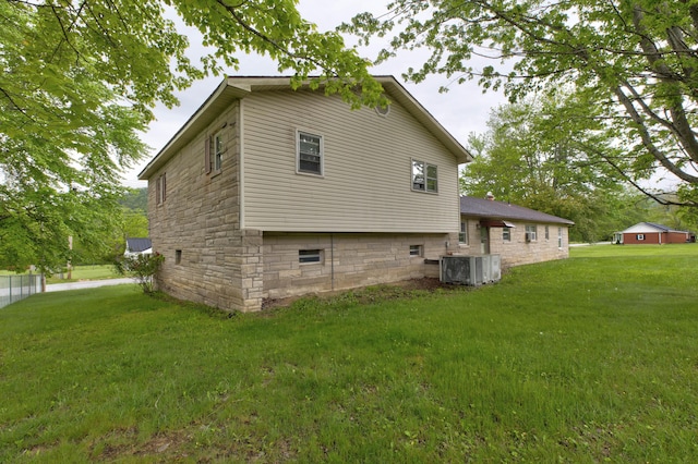 view of home's exterior with a lawn and central AC unit