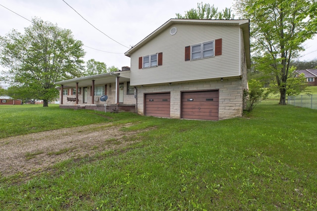 tri-level home featuring driveway, a garage, fence, and a front yard